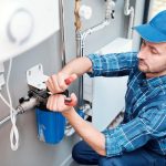 WeServe | a man with a blue shirt and hat working on a plumbing problem