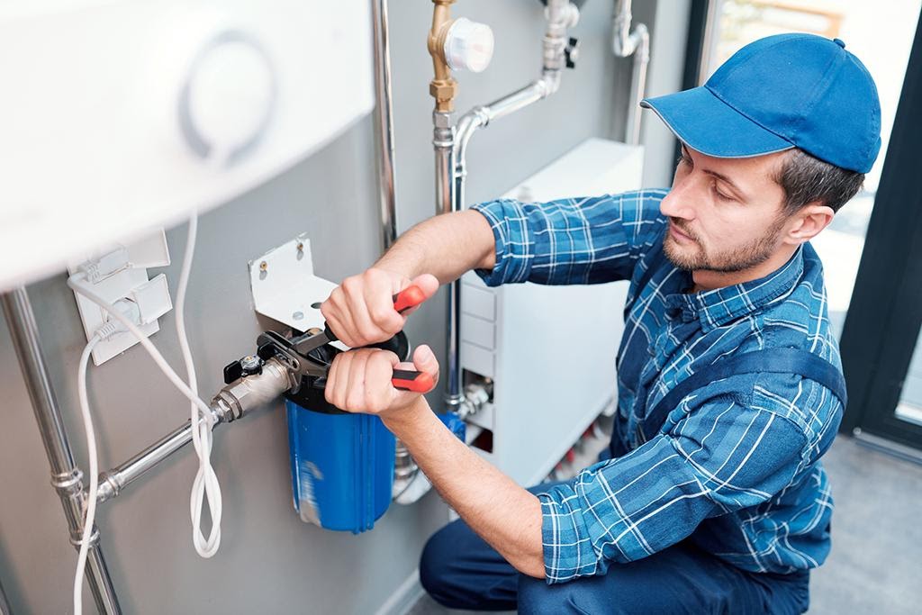 WeServe | a man with a blue shirt and hat working on a plumbing problem